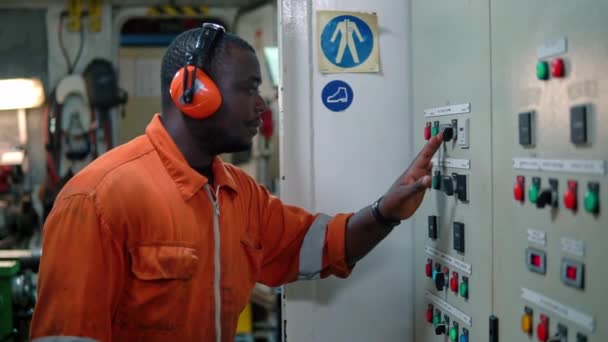 African Marine engineer officer in de motor controlekamer ECR. — Stockvideo