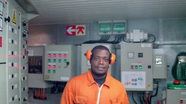 Africký strojní důstojník v řídící místnosti motoru ECR. — Stock video