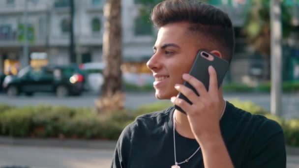 Человек на улице разговаривает по мобильному телефону — стоковое видео