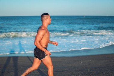 Plajda Dövmeli vücut geliştirmeci seksi erkek antrenör.