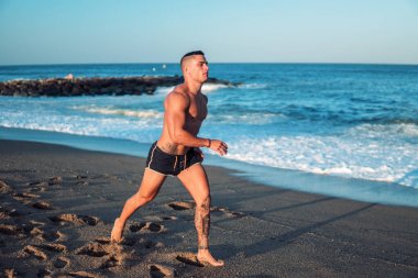 Plajda Dövmeli vücut geliştirmeci seksi erkek antrenör.