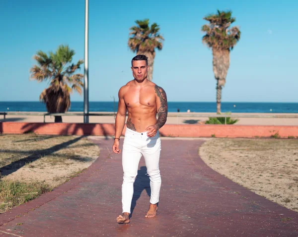 Tatuado culturista sexy entrenador masculino en la playa . —  Fotos de Stock