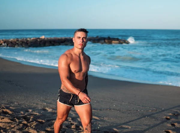 Tatuado culturista sexy entrenador masculino en la playa . —  Fotos de Stock