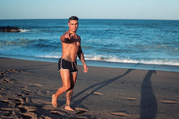 Tatuado culturista sexy entrenador masculino en la playa . —  Fotos de Stock