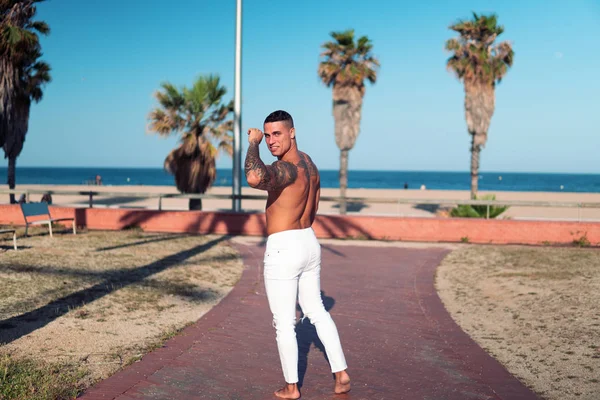 Tatuado culturista sexy entrenador masculino en la playa . —  Fotos de Stock