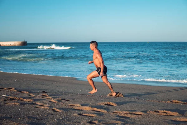 Tatuado culturista sexy entrenador masculino en la playa . —  Fotos de Stock