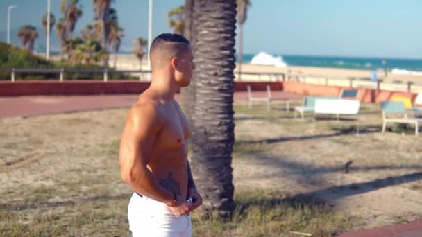 Tatuado culturista sexy entrenador masculino en la playa . — Vídeos de Stock