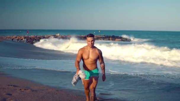 Tatuado culturista sexy entrenador masculino en la playa . — Vídeo de stock