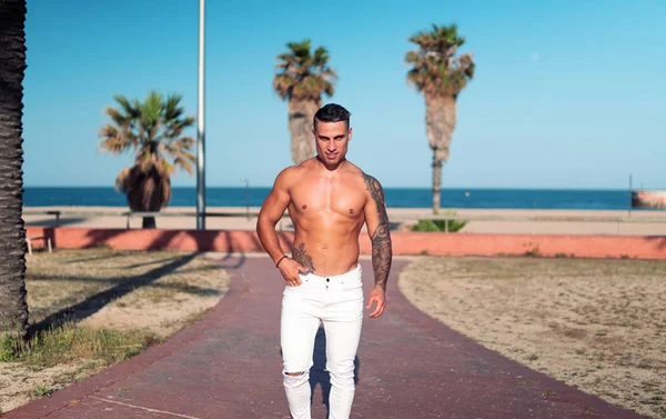 Tatuado culturista sexy entrenador masculino en la playa . —  Fotos de Stock