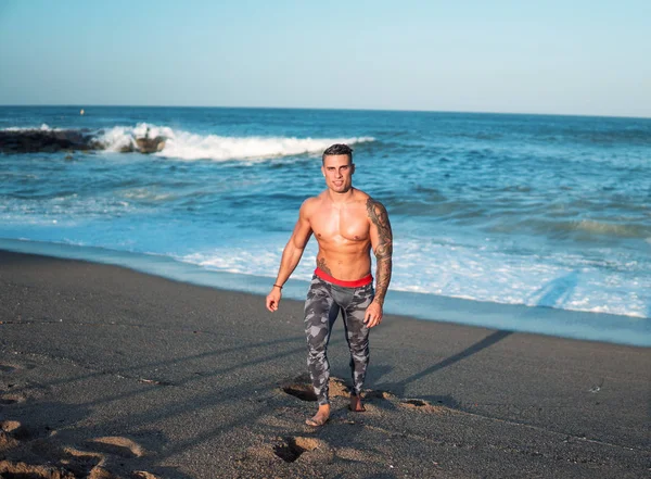 Tatuado culturista sexy entrenador masculino en la playa . —  Fotos de Stock