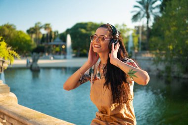 yeşil parkta güneş gözlüğü takan transseksüel model