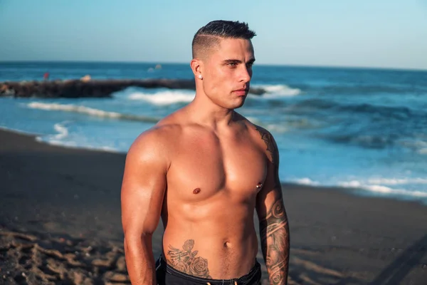 Tattooed bodybuilder sexy male coach at the beach. — Stock Photo, Image