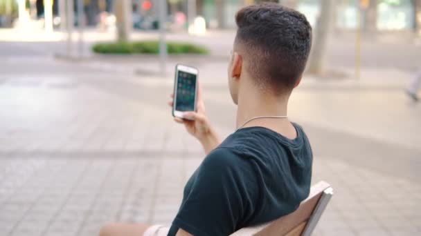 Hombre en la calle charlando en un teléfono celular — Vídeo de stock