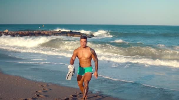 Tatuato bodybuilder sexy allenatore maschile in spiaggia . — Video Stock