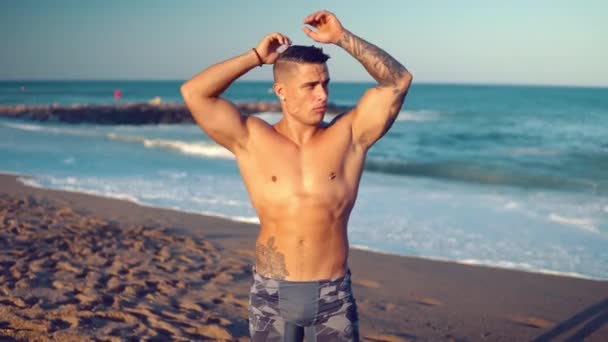 Tätowierter Bodybuilder sexy männlicher Trainer am Strand. — Stockvideo