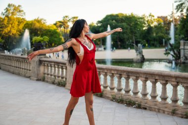 Ladyboy dövmeli transseksüel modeli yeşil parkta dans ediyor