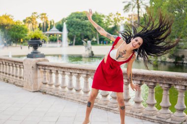 Ladyboy dövmeli transseksüel modeli yeşil parkta dans ediyor