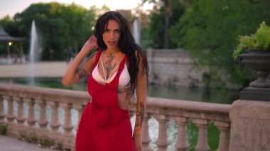 Ladyboy dövmeli transseksüel modeli yeşil parkta dans ediyor