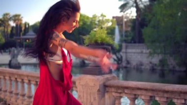 Ladyboy dövmeli transseksüel modeli yeşil parkta dans ediyor