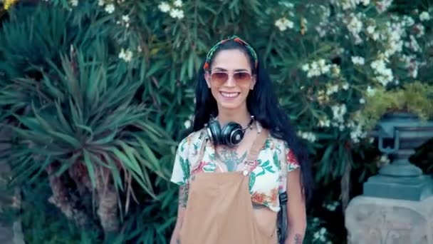 Model transseksualistów ubrany w okulary przeciwsłoneczne w zielonym parku — Wideo stockowe