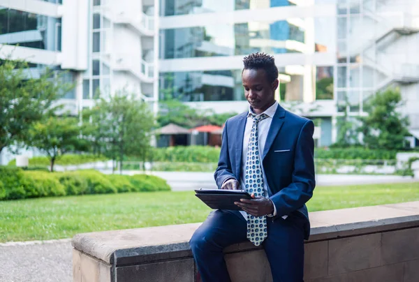 Empresário afro-americano segurando notebook laptop vestindo terno azul — Fotografia de Stock