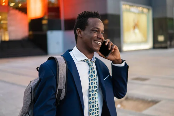 Hombre de negocios afroamericano sosteniendo teléfono móvil con traje azul —  Fotos de Stock