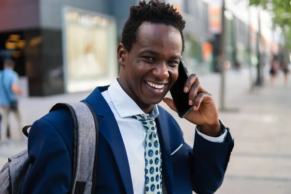 Hombre de negocios afroamericano sosteniendo teléfono móvil con traje azul —  Fotos de Stock