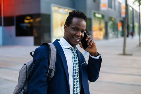 Hombre de negocios afroamericano sosteniendo teléfono móvil con traje azul —  Fotos de Stock