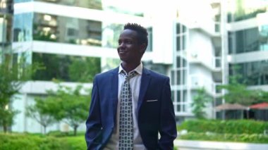 Afro-Amerikan işadamı ayakta mavi takım elbise giyiyor