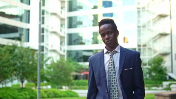 Un homme d'affaires afro-américain portant un costume bleu marche — Video