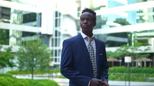 青いスーツを着たアフリカ系アメリカ人のビジネスマンが立っている — ストック動画