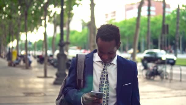 Hombre de negocios afroamericano sosteniendo portátil portátil con traje azul — Vídeo de stock