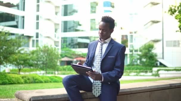 Mavi takım elbise giyen dizüstü bilgisayar tutan Afro-Amerikalı işadamı — Stok video