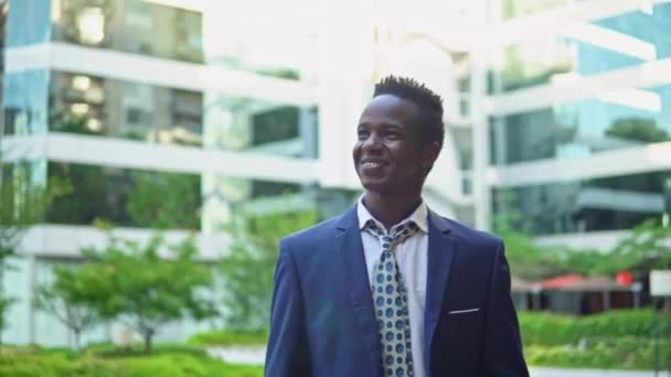 Hombre de negocios afroamericano con traje azul de pie — Vídeos de Stock