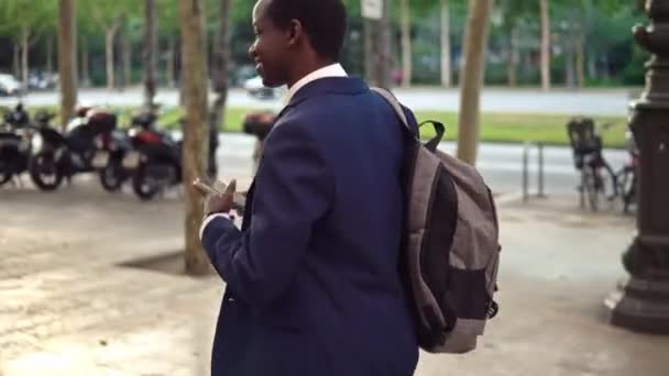 Uomo d'affari afroamericano in possesso di notebook con indosso abito blu — Video Stock