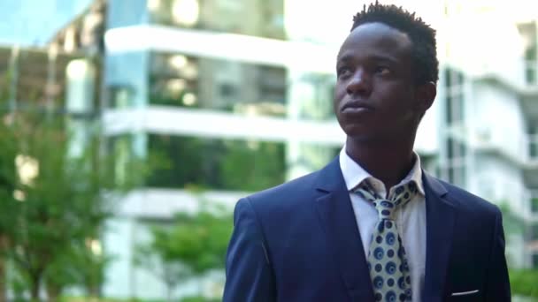 青いスーツを着たアフリカ系アメリカ人のビジネスマンが立っている — ストック動画