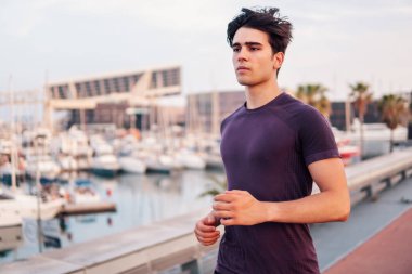 Gökdelenler arka plan sırasında parkta çalışan genç atletik adam