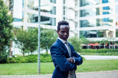 Mavi takım elbise giyen dizüstü bilgisayar tutan Afro-Amerikalı işadamı