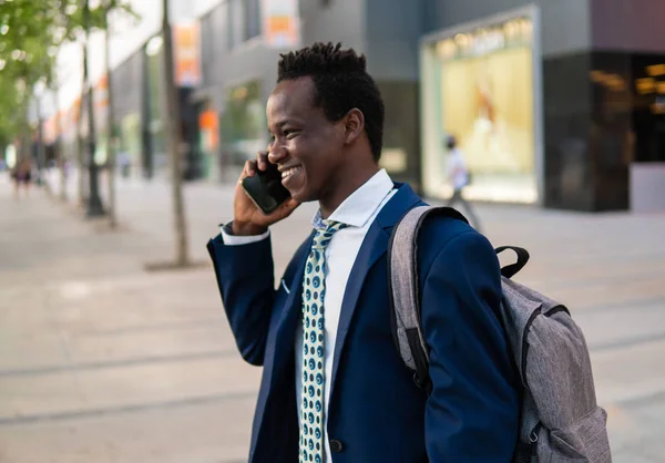 Hombre de negocios afroamericano sosteniendo teléfono móvil con traje azul —  Fotos de Stock