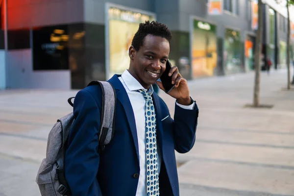 Hombre de negocios afroamericano sosteniendo teléfono móvil con traje azul —  Fotos de Stock