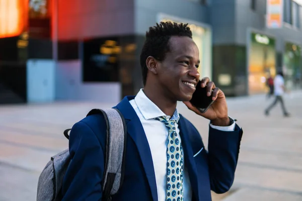 Hombre de negocios afroamericano sosteniendo teléfono móvil con traje azul —  Fotos de Stock