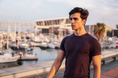 Gökdelenler arka plan sırasında parkta çalışan genç atletik adam