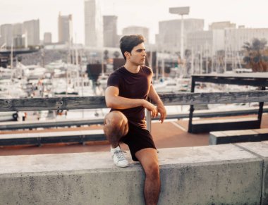 Gökdelenler arka plan ile parkta çalışan sonra genç atletik adam