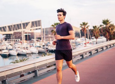 Gökdelenler arka plan sırasında parkta çalışan genç atletik adam