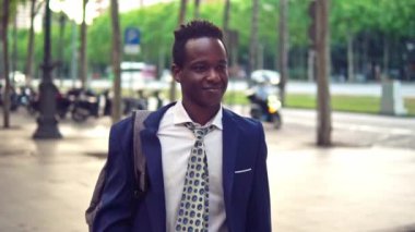 Mavi takım elbise giyen dizüstü bilgisayar tutan Afro-Amerikalı işadamı