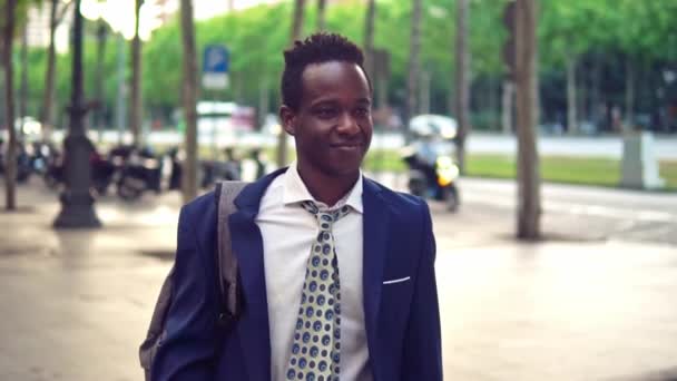 Un homme d'affaires afro-américain tenant un ordinateur portable portant un costume bleu — Video
