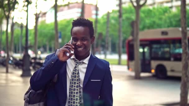 Un homme d'affaires afro-américain tenant un ordinateur portable portant un costume bleu — Video