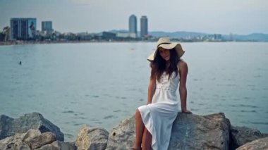 Beyaz elbise ve pamela şapka oturan pretty kadın