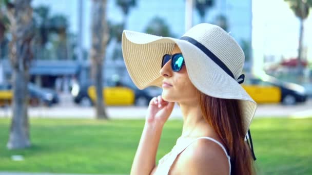 Jolie femme en robe blanche et chapeau pamela marche — Video