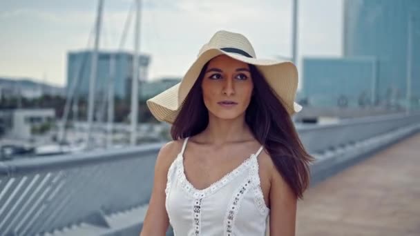 Jolie femme en robe blanche et chapeau pamela marche — Video